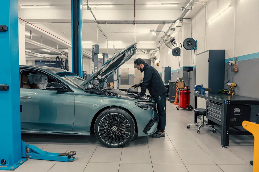 Mecánico trabajando en el motor de un coche en un taller moderno